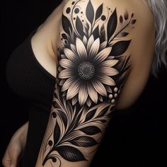 a woman's arm with black and white tattoos on it, including a sunflower