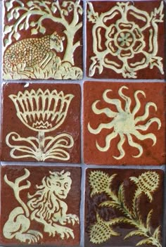 some decorative tiles with animals and flowers on them in gold, red and brown colors