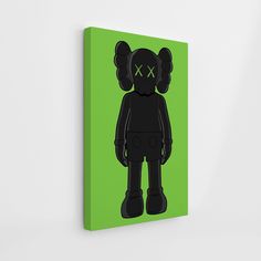 a black teddy bear with green eyes on a green background canvas mounted to a wall