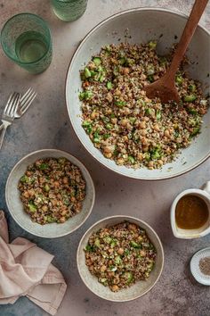 three bowls filled with food sitting on top of a table next to cups and spoons