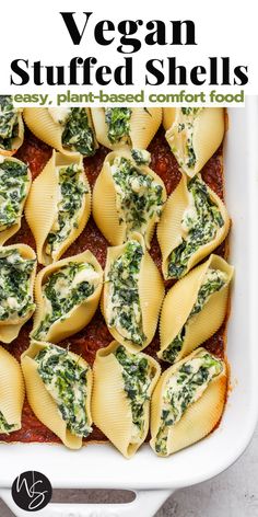 vegan stuffed shells in a white casserole dish with spinach and cheese