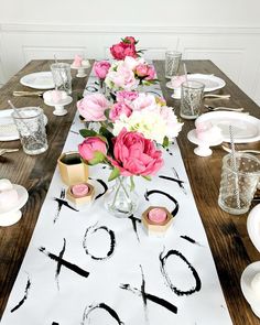 the table is set with pink and white flowers