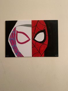 a piece of art that looks like a spiderman mask is hanging on the wall