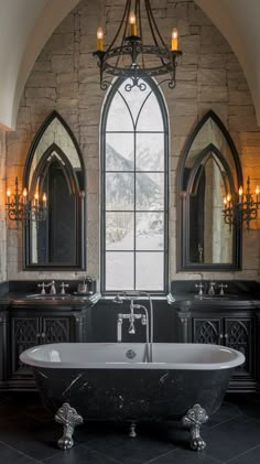 a large bathroom with an arched window and black marble bathtub in front of two sinks