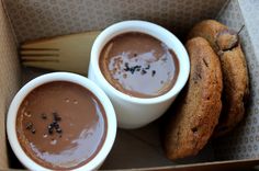 two cups of chocolate pudding and cookies in a box