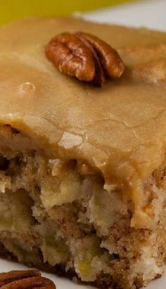 a close up of a piece of cake on a plate with pecans in the background