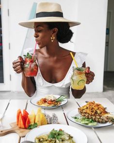 a woman sitting at a table with food and drinks in front of her on instagram