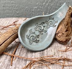 two spoons sitting next to each other on top of a piece of driftwood