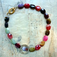 "This is a stunning statement necklace. Earth tone agate stones create a very unique piece. An 18k gold plated circle is placed on one side to give an asymmetric modern look. The colors are red, pink, brown, ocher, very light green, purple. Agate's most noticeable properties overall are balancing yin/yang energy, courage, protection, healing, and calming. Historically it was placed in water for cooking or drinking to dispel sickness. The Metaphysical and Healing Properties Lore of any specific t Summer Tones, Necklace Stones, Natural Gemstone Necklace, Nugget Necklace, Summer Necklace, Agate Necklace, Agate Stone, Gemstone Necklace, Beaded Bracelet