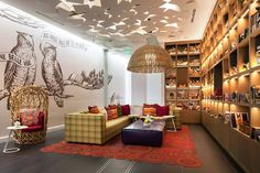 a living room filled with lots of furniture and bookshelves next to a library