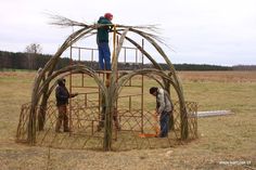 two men working on a structure made out of sticks