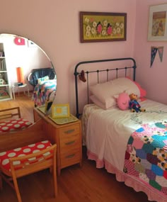 a child's bedroom with pink walls and wooden floors