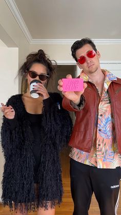 a man and woman dressed up in costumes posing for the camera with their cell phones