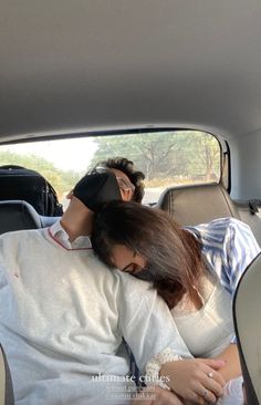 two people sleeping in the back of a car with blindfolds on their heads