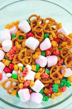 a glass bowl filled with candy and pretzels