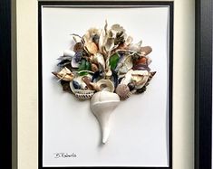 there is a framed picture with shells in it