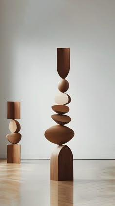 an abstract sculpture made out of wood stacked on top of each other in front of a white wall