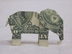 an elephant made out of money sitting in the snow