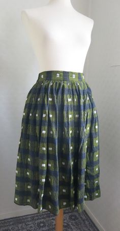 "Size Small. Skirt made between the the 30s to 50s with a cool plaid pattern in the colors black, green and white. The fabric is a thick, cozy cotton flannel. The look of the skirt is kind of 50s but I think the skirt could be much older, and maybe altered in the 50s. It has no closures, but I added two hooks and thread loops to make it fit on the mannequin. No other flaws that I can see. Waist: 66 cm - 26 in Hip: Free Length: 71 cm - 23 in Tracking is not included in the price because of the hi Fitted Cotton Plaid Skirt, Vintage Plaid Cotton Skirt, Retro Plaid Cotton Skirt, Retro Gingham Cotton Skirt, Fitted Cotton Gingham Skirt, Small Skirt, Green Flannel, The 50s, Cotton Flannel