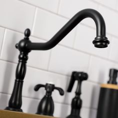 black faucets and soap dispensers in a bathroom