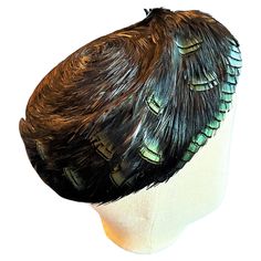 Circa 1955-1965 France An oval-shelled bibi "coiffé" waxed with superimposed rows of black feathers revealing iridescent green feathers (partridge?), like shiny beetle shells and dating from the late 1950s. The rigid shell is lined with Tarlatane to match the shape, and features a thin elastic band for a secure hold on the bun. The work comes from the tradition of French Plumassiers (feather makers), established as guilds since the 18th century, who worked mainly for French Haute Couture Houses. Shiny Beetle, French Haute Couture, Green Feathers, Iridescent Green, Stuffed Shells, Partridge, Black Feathers, Irises, John Galliano