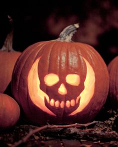 two pumpkins with carved faces are sitting on the ground in front of other pumpkins