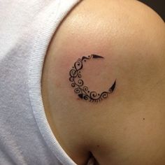 a woman's upper back shoulder tattoo with an arrow in the shape of a crescent