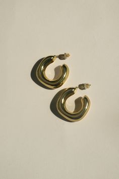 The Gold Molten Hoop Earrings are a striking fusion of organic design and timeless elegance. These hoops feature a fluid, molten texture that captures the essence of raw beauty. Each piece is hand-finished to create a unique, flowing pattern, ensuring that no two pairs are exactly alike. Designed to be both bold and versatile, they are perfect for elevating any look, from casual to sophisticated. Demi-Fine Jewelry: Protect your demi-fine jewelry by removing it during activities such as washing hands, swimming, exercising, cleaning, and applying personal body products. Maintain shine by avoiding contact with soaps, perfume, lotion, makeup, and cleaning products. Wear rubber or metal safety backs with earrings to prevent loss. Store jewelry in a dry area, not the bathroom. Flowing Pattern, September Birthstone Jewelry, Hammered Hoop Earrings, August Birthstone Jewelry, July Birthstone Jewelry, Gold Jewelry Earrings, Raw Beauty, Zodiac Jewelry, Demi Fine Jewelry