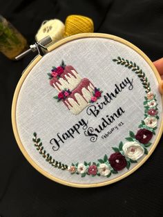 someone is holding up a birthday cake embroideryed on a hoop