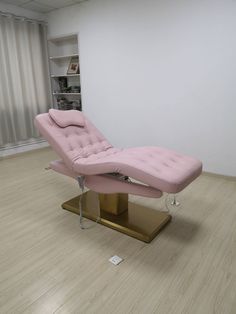 a pink chaise lounge chair sitting on top of a wooden platform in an empty room