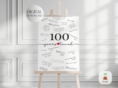 an easel with the words 100 great loved written on it in front of a white wall