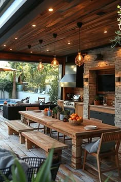 an outdoor kitchen and dining area with wood flooring, stone walls and ceiling lights