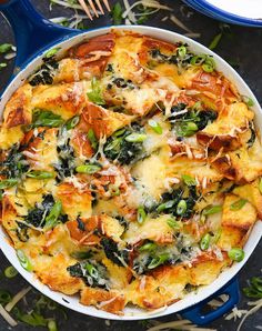 a casserole dish with spinach, cheese and other toppings in it