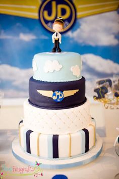 there is a cake that looks like an airplane on the top and blue, white, and black stripes