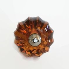 an orange glass flower with a diamond in the center