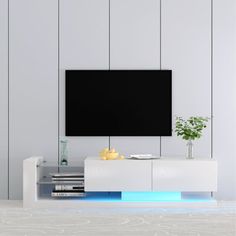 a white entertainment center with a black screen mounted on the wall