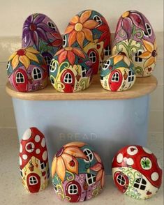 several colorfully painted rocks sitting on top of a blue container next to each other