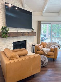 a living room filled with furniture and a flat screen tv mounted on the wall above a fireplace