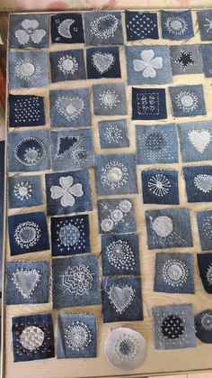 a table topped with lots of different pieces of cloth covered in white thread and flowers