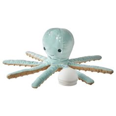 an octopus stuffed animal sitting on top of a white egg shell with its eyes open