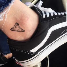 a woman's foot with a small tattoo on her left ankle and an arrow in the middle