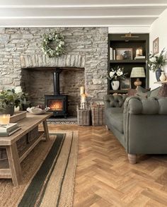 a living room filled with furniture and a fire place next to a wooden floored wall