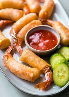 a white plate topped with cucumbers and fried food next to ketchup