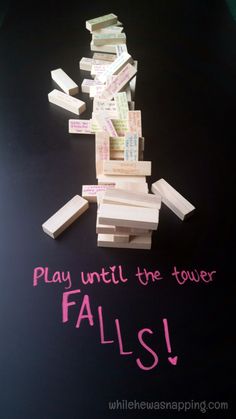 the words play until the tower falls written on a blackboard with pink writing and pieces of wood