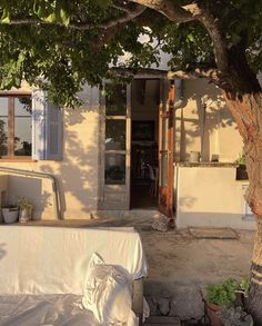 a couch under a tree in front of a house