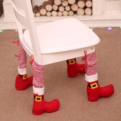 a white chair with christmas stockings and red boots sitting on top of it's legs