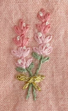 pink and green flowers are embroidered onto the fabric