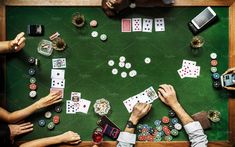 several people playing cards at a table with chips and cell phones on it, all around them