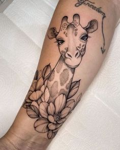 a giraffe with flowers on it's leg is shown in black and white