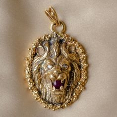 A vintage 1970s Leo lion pendant in 14 karat solid yellow gold,  featuring a lion's head in relief with a flowing mane, diamond eyes and set with a natural ruby in its' open mouth. It has a wide bale accomodating a variety of chains. This unisex pendant can be worn on its own or stacked with another piece.  Traditionally the lion represents majesty, strength, and courage.  The symbol of the lion is representative of the zodiac sign of Leo the lion who symbolizes those born between July 23 and Au Lion Jewellery, Lion Necklace Mens, Lion Crest, Leo The Lion, Gold Lion Pendant Jewelry, Lion Charm, Lion Necklace, Leo Lion, Lion Pendant